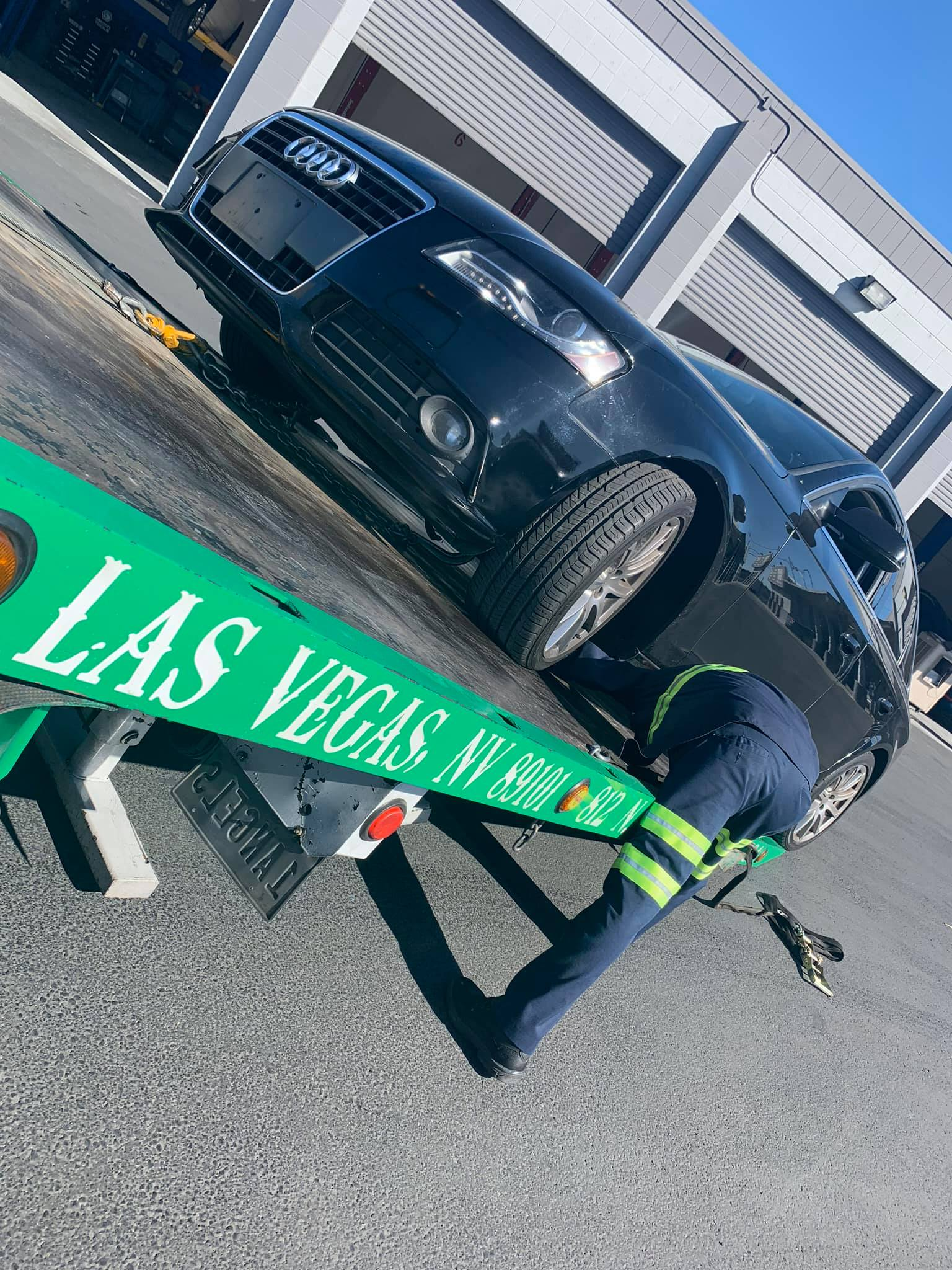 6 Angels crew securing a vehicle onto the flatbed tow truck